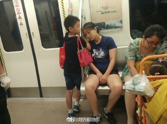 懂事男孩坐地铁用手为妈妈垫着睡觉获好评